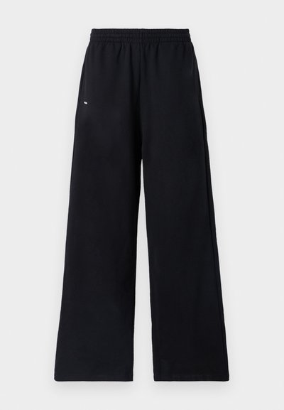 Μαύρες φαρδιές φόρμες με ελαστική μέση, κατασκευασμένες από μαλακό ύφασμα. Περιλαμβάνουν ελάχιστες λεπτομέρειες με καθαρές γραμμές και χωρίς ορατά λογότυπα.