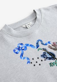 Halli dressipluus, millel on sinise lindiga disain, koala illustratsioon ja dekoratiivsed elemendid. Sooniline kaelus ja pehme tekstuur. Suurus M.