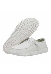 Scarpe da ginnastica bianche in tela con punta arrotondata, design a basso profilo e lacci. Suola in gomma testurizzata con battistrada pattern per una migliore aderenza.