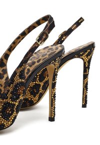 Schwarze und goldene High-Heels mit Slingback verfügen über ein Leopardenmuster, das mit Pailletten verziert ist, und haben eine spitze Zehenpartie sowie einen Stilettopfer.
