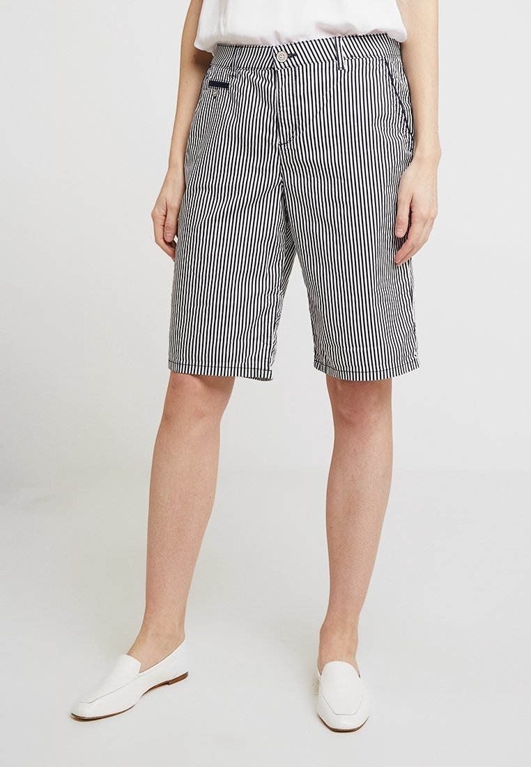Pruhované kraťasy v černé a bílé barvě s volným střihem, vybavené knoflíkovým zapínáním a bočními kapsami pro zvýšení funkčnosti.