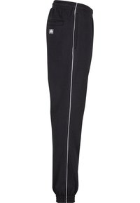 Sorte sweatpants med elastisk midje, hvitt sideliste og mansjetter på kanten. Har en liten logo-lapp og en baklomme.