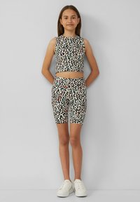 Tweedelig outfit met luipaardprint, bestaande uit een mouwloze crop top en bijpassende shorts. Rekbare stof met contrasterende pastelaccenten.