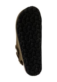 Semelle en caoutchouc noire avec motif texturé, semelle extérieure comportant des rainures circulaires, et partie supérieure beige avec une fermeture à boucle latérale.