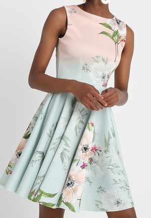 Robe pastel sans manches avec imprimé floral, corsage ajusté et jupe évasée portée par une personne à peau foncée.