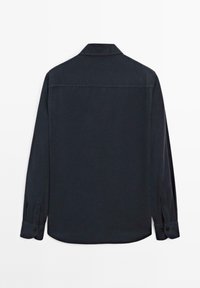 Camicia a maniche lunghe blu scuro con colletto, pattina posteriore singola, orlo curvo e polsini con bottone. Realizzata in un tessuto a trama liscia.