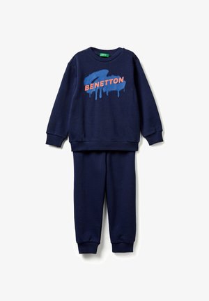 Completo per bambini composto da felpa e pantaloni blu navy con polsini a coste, con logo "BENETTON" in design splash di vernice rosa e blu sulla parte superiore.