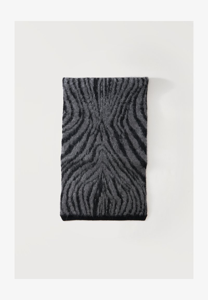 Écharpe gris foncé et noire avec une texture duveteuse et un motif rayé ondulé abstrait, posée à plat sur un fond blanc.