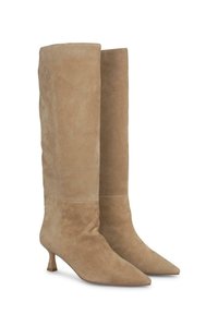 Kniehoge beige suède laarzen met een spitse neus en lage blokhak. Zachte textuur met minimale naden en geen zichtbare hardware.
