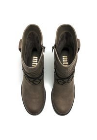 Bottines en daim marron avec un bout arrondi, des détails de sangle noire décorative et une fermeture éclair sur le côté, dotées d'une doublure intérieure texturée.