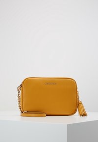 Gul læder crossbody taske med en tekstureret overflade, guldhardware og en dekorativ kvast. Har en aftagelig rem og prægede logo.