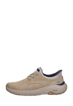 Beige casual veterschoen met een bovenwerk van gestructureerde stof, een gevoerde zool met het label "Arch Fit" en een donkerblauwe binnenvoering en hielaccenten.