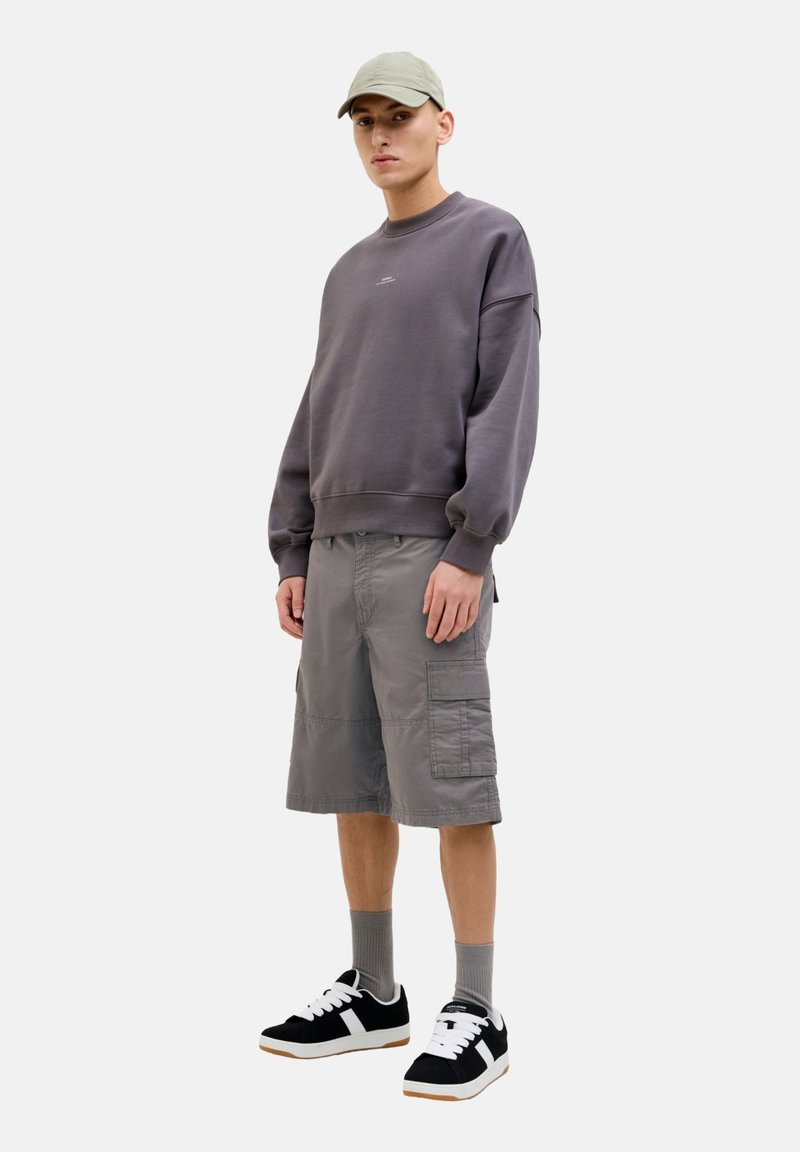 Gray sweatshirt and gray cargo shorts with pockets, paired with black sneakers featuring white accents and gray socks. Simple cap on head.