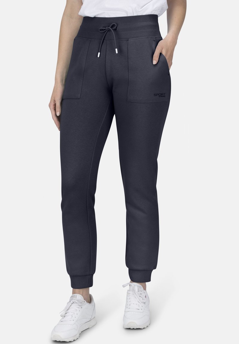 Marineblaue Sweatpants mit einem Kordelzugbund, zwei Vorderaschen, gerippten Bündchen und einem Logo-Detail am linken Oberschenkel. Geeignet für Sportbekleidung.