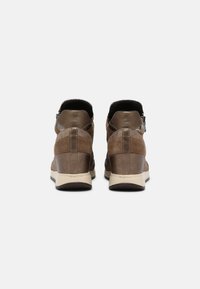 Bruna läder- och mockasnörkängor med vadderad krage, texturerade ytor och beige gummisålar. Har en sidodil som gör dem lätta att ta på.