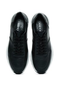 Sneakers in pelle nera caratterizzati da una superficie testurizzata, punta rotonda, chiusura con lacci e suola in gomma bianca con dettagli perforati.