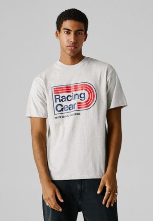 Graues Baumwoll-T-Shirt mit großem roten und blauen Schriftzug "Racing Gear" und darunter "Red Bull Racing". Mit kurzen Ärmeln und Rundhalsausschnitt.