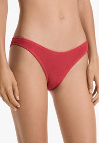 Inferiore di bikini rosso in tessuto strutturato con design a vita bassa, caratterizzato da sottili fascette laterali e copertura minima. Finitura liscia.