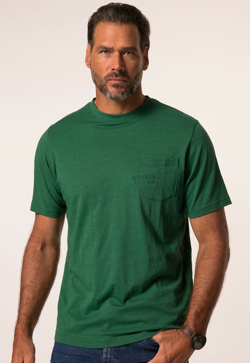 Camiseta verde de manga corta hecha de tejido suave, con un bolsillo en el pecho con texto en relieve, cuello redondo y un ajuste relajado.