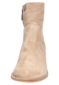 Stivale alla caviglia in suede beige con punta arrotondata, chiusura con zip laterale e suola piatta. Texture morbida con dettagli di cucitura minimi.