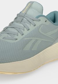 Ανοιχτό μπλε sneaker Reebok με επάνω μέρος από διχτυωτό υλικό, ομοιόχρωμα κορδόνια και παχιά μπεζ σόλα, εμφανιζόμενο από μπροστινή πλευρική γωνία.