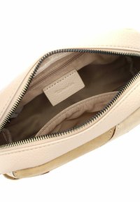 Beige läderväska med zipstängning, som har en slät yta, ett litet kortfack och mjuk tygfoder.