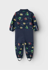 Granatowy kombinezon dziecięcy z kolorowymi nadrukami pojazdów budowlanych, elastycznymi mankietami i przymocowanymi paskami na nogawkach.