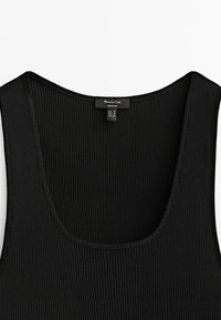 Sort ribbet tanktop med bred scoop-udskæring og smalle stropper, der har et struktureret stof og et mærke, der viser størrelse og mærkenavn.