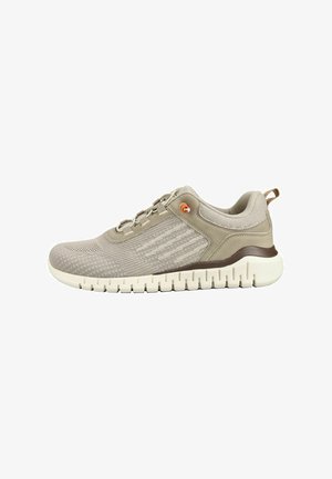 Sneaker sportiva beige chiaro con tomaia in maglia, dettaglio marrone vicino alla suola, suola bianca spessa e dettaglio arancione vicino ai lacci.