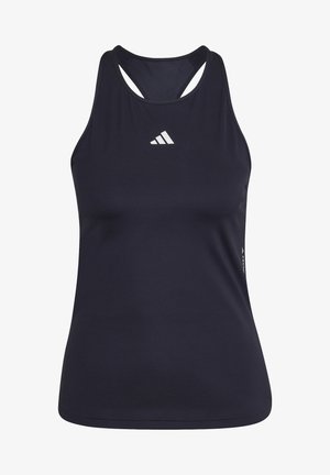 Osoba nosząca czarne legginsy, granatową bluzkę bez rękawów i czarne buty sportowe, trzymająca czarną hantlę w prawej ręce.