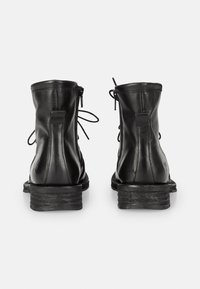 Sorte læder ankelstøvler med en mat finish. Har en bagvending, snøre detaljer og en tekstureret sort sål for forbedret greb.