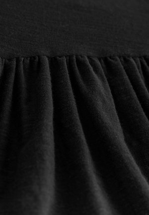 Zwart stof met een gestructureerd oppervlak, gekenmerkt door samengevoegde plooien, die zachtheid en een uniforme donkere kleur over het geheel vertoont.