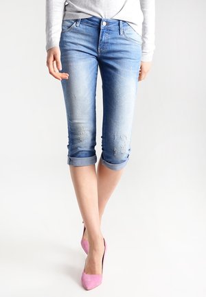 Pantalones capri de mezclilla azul claro con un diseño ligeramente desgastado, puños enrollados, estilo de cinco bolsillos, acabado desgastado y forma ajustada.