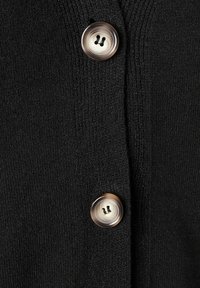 Black knit cardigan featuring two large, smooth, round buttons with a light brown hue and dark thread detail, showcasing ribbed texture.