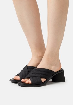 Czarne sandały na obcasie z krzyżującymi się paskami z tkaniny o textured wykończeniu, otwartym noskiem i solidnym obcasem.