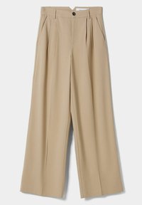 Beżowe spodnie o szerokich nogawkach z gładkiego materiału, z plisami z przodu, zapięciem na guzik oraz kieszeniami po bokach.