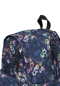 Sac à dos floral de couleur bleu marine foncé avec un motif de fleurs multicolores. Il possède des zips et des cordons noirs, ainsi qu'une poignée de transport supérieure.