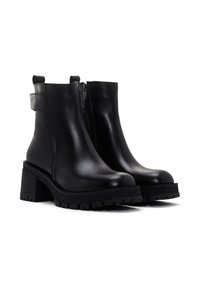 Botas negras de cuero hasta el tobillo con cierre lateral, suela de plataforma texturizada y tacón cuadrado. Cuentan con una lengüeta en la parte posterior para facilitar su uso.