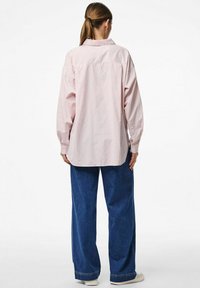 Heled roosa triibuline särk pika varrukaga ja krae, koos laia sinise teksapükstega. Lihtne disain, juhuslik lõige ja pehme tekstuur.