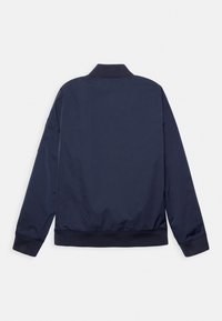 Navy nylon bomber jacket with a ribbed collar and cuffs, featuring a smooth texture and elastic waistband; no visible hardware or patterns.