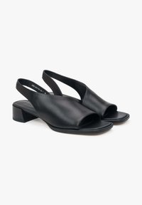 Zwarte leren slingback schoenen met een open teen en een lage blokhak. Glad textuur en minimalistisch ontwerp.