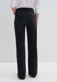 Mustat leveälahkeiset farkut, jotka on valmistettu denimiaineesta. Niissä on korkeavyötärö, kaksi takataskua ja suora leikkaus nilkkoihin asti.