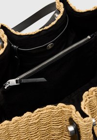 Borsa in paglia intrecciata con interno in tessuto nero; presenta una tasca con zip, hardware argentato e un'apertura superiore testurizzata con bordo intrecciato.