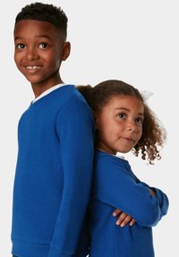 Due bambini indossano felpe blu a girocollo abbinate con bordi bianchi. Il tessuto sembra morbido e il design è semplice, senza motivi.