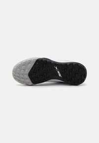 Shoe sole featuring a textured black rubber design with gray accents. Includes a distinct traction pattern and logo detail.