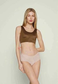 Brūns īss tops un gaiši bežīgas bikses, izgatavotas no gludas auduma, ar vienkāršu dizainu, apaļu kakla izgriezumu un gludu siluetu.