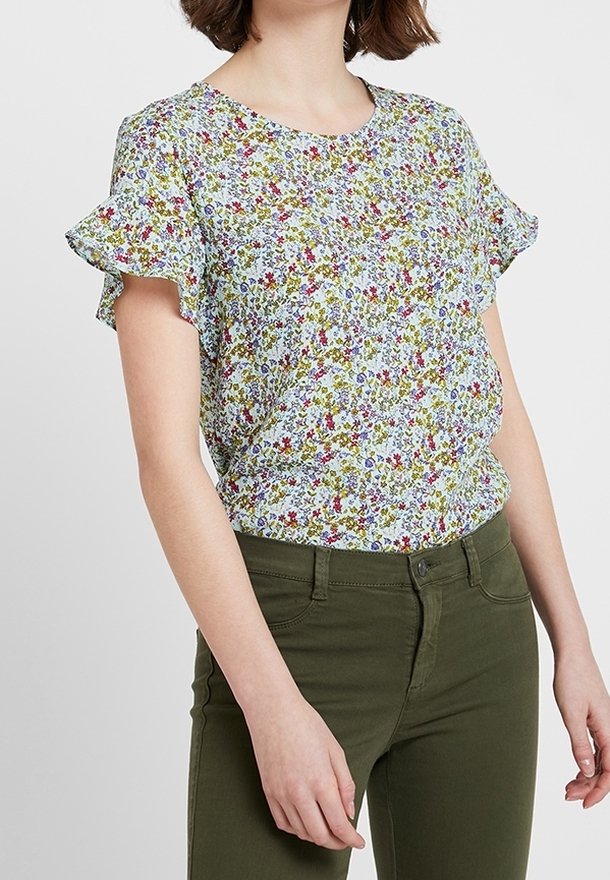 Květinová blůza s krátkým rukávem a kulatým výstřihem, s světle modrým pozadím a barevnými květinovými vzory. Měkká tkanina.