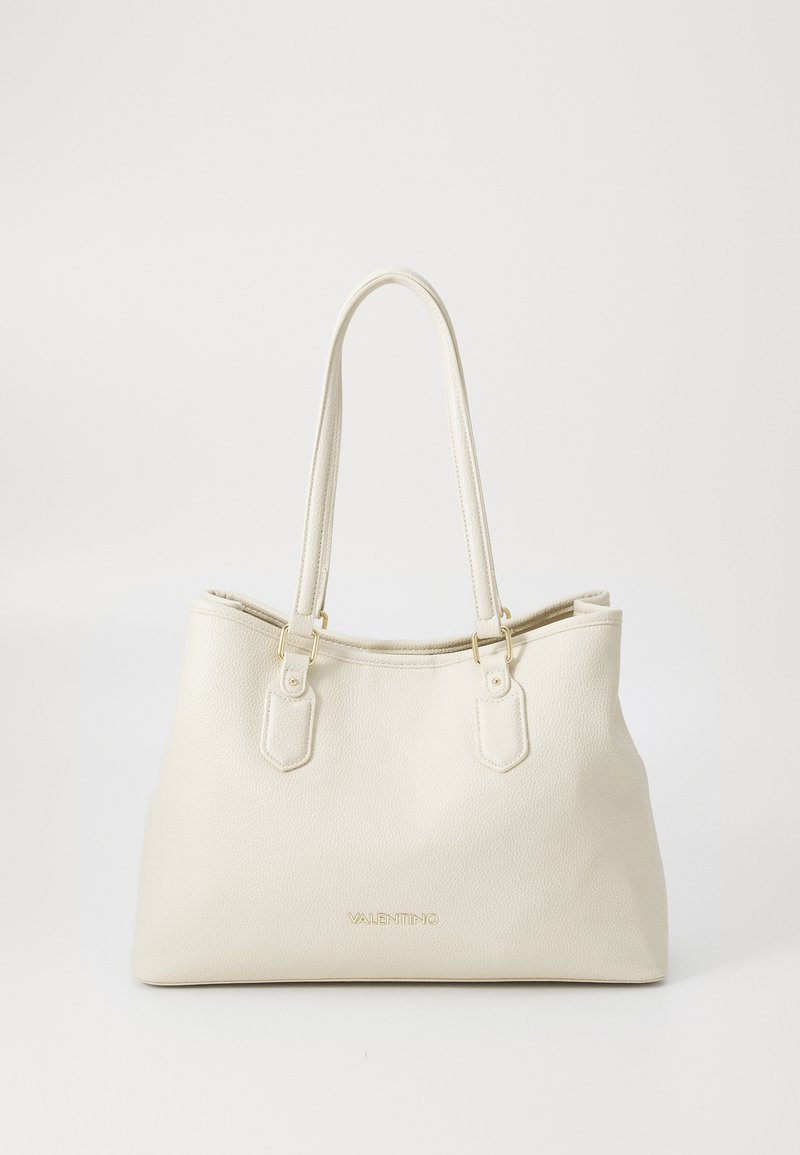 Bolsa tote de textura cremosa com acabamentos dourados, alças duplas para o ombro e logótipo da marca em relevo visível na frente.