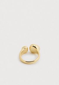 Χρυσό δαχτυλίδι με στριφτό σχέδιο. Διαθέτει ομαλές καμπύλες και στρογγυλεμένες άκρες. Κατασκευασμένο από γυαλισμένο μέταλλο με λαμπερή υφή.