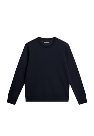 Mörk marinblå crewneck sweatshirt gjord av mjukt tyg. Har ribbade ärmslut och fåll, med en subtil logotypdetalj på bröstet.